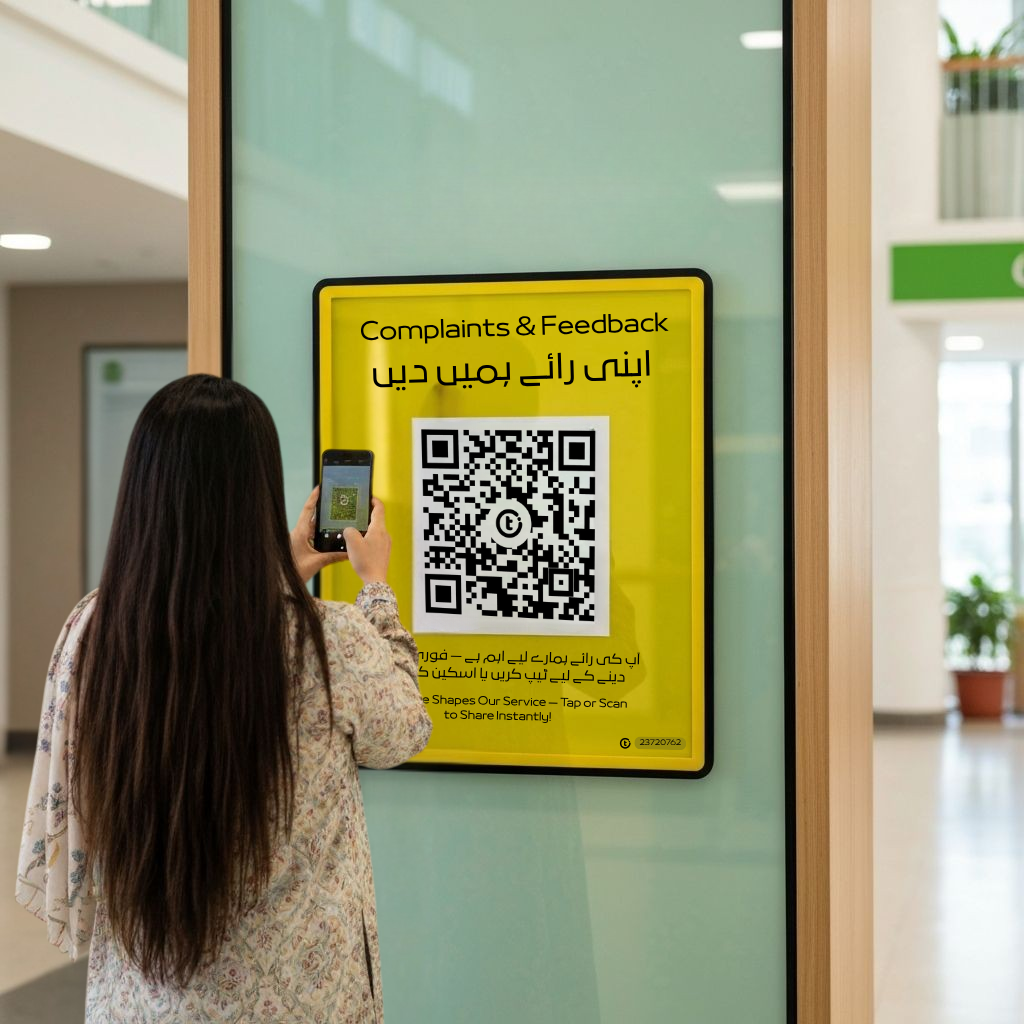 TapX digital complaints and feedback QR touchpoint installed at Pakistani bank with bilingual signage showing Tap or Scan to share feedback instantly