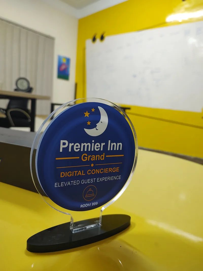 Premier Inn Grand branded circular acrylic GolTap standing on its black base